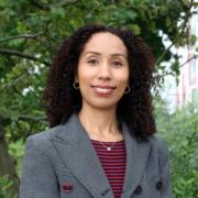 Outdoor headshot of Christine Tang standing in front of trees.