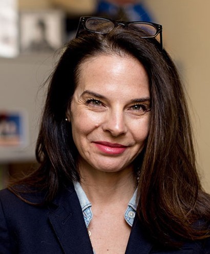 Headshot of Gail JOseph smiling and facing the camera, glasses are resting on top of her head.