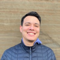 Headshot of Nick Terrones in front of a brown backdrop.
