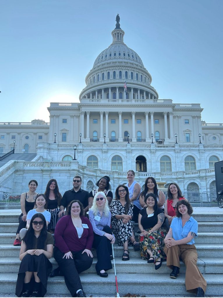 The group of graduate students in early childhood policy sitting with Gail Joseph on the steps of the capital building in Washington D.C.