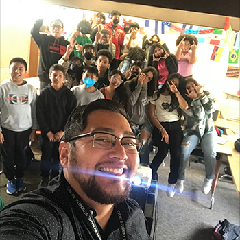 Salvador Gomez poses for a selfie with his students.