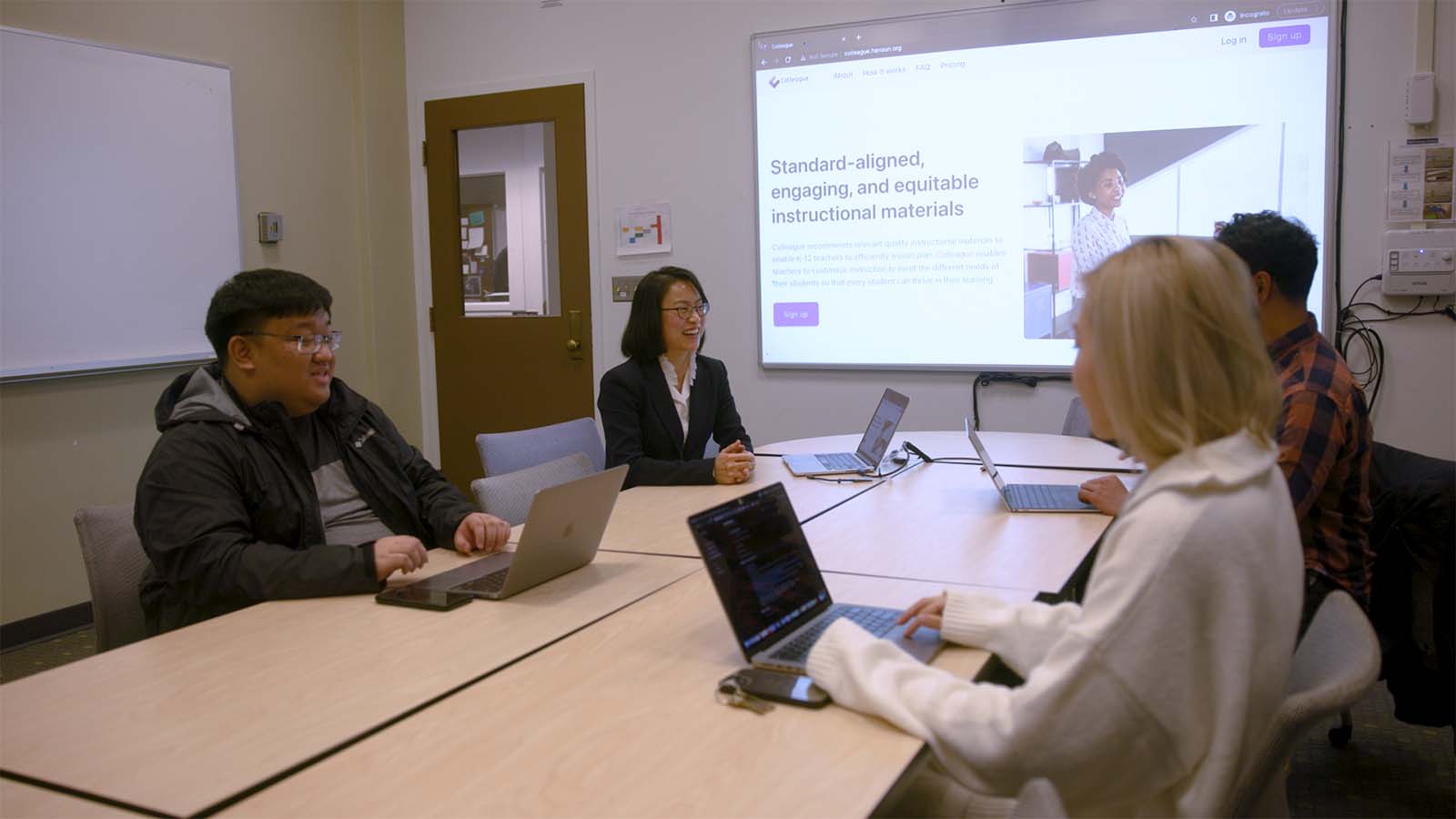 Dr. Min Sun at a conference table showcasing Colleague software