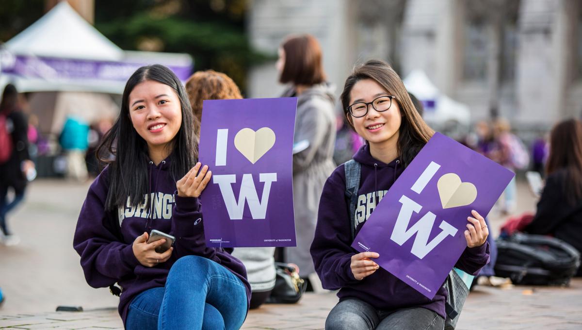 Two UW students holding up a I love W poster